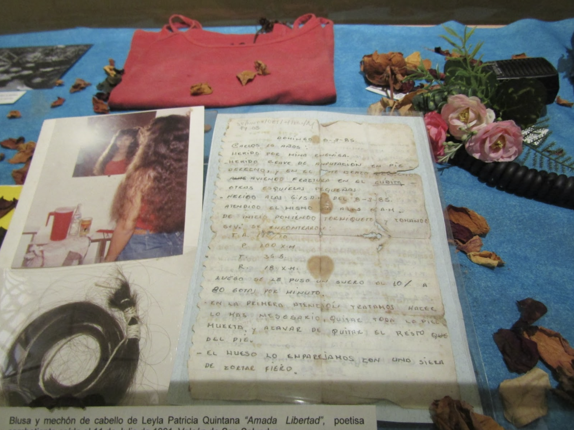 Vitrine containing photograph, handwritten poems, belongings, and a lock of hair of Amada Libertad (Leyla Patricia Quintana Marxelly) from the historical archive of the Museo de la Palabra y Imagen (MUPI), San Salvador, El Salvador. Image used with permission from MUPI. 